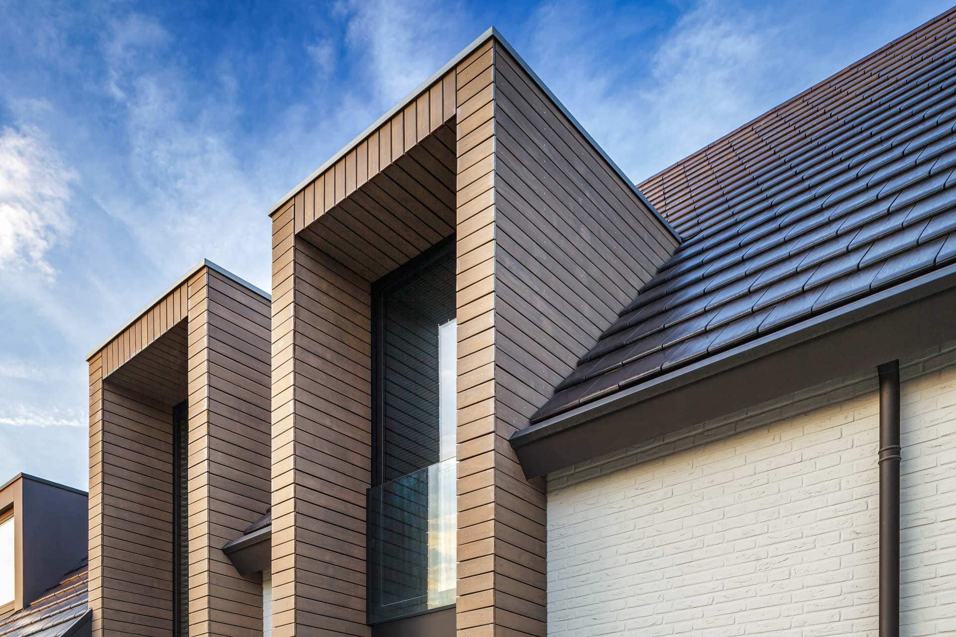 Details van de buitenbekleding zichtbaar van de twee enorme raampartijen van de nieuwbouwvilla in Vlijmen.