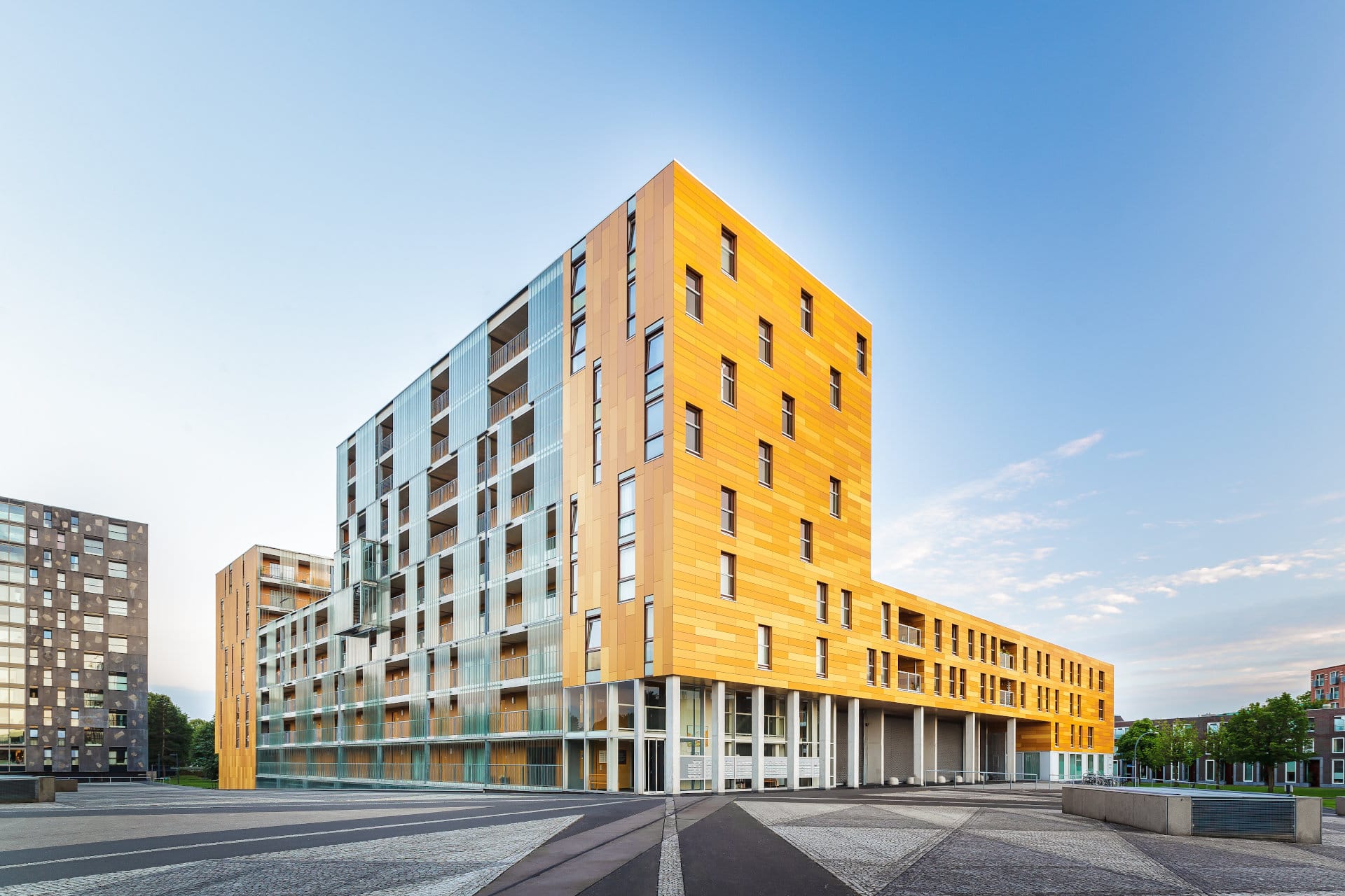 Opvallend geel appartementencomplex met een eigentijdse uitstraling en veel raampartijen gelegen in een levendig stadspark.